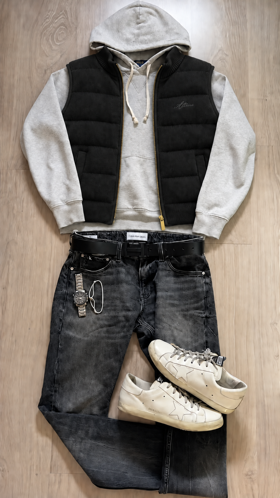 Black Knitted Vest layered over a grey hoodie with dark jeans